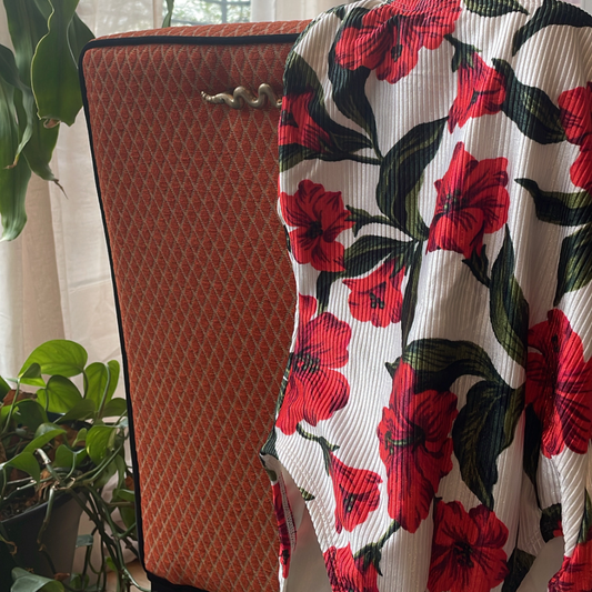 Red patterned vintage swim suit is draped over a vintage chair for display from Chicago Vintage Store in West Town.