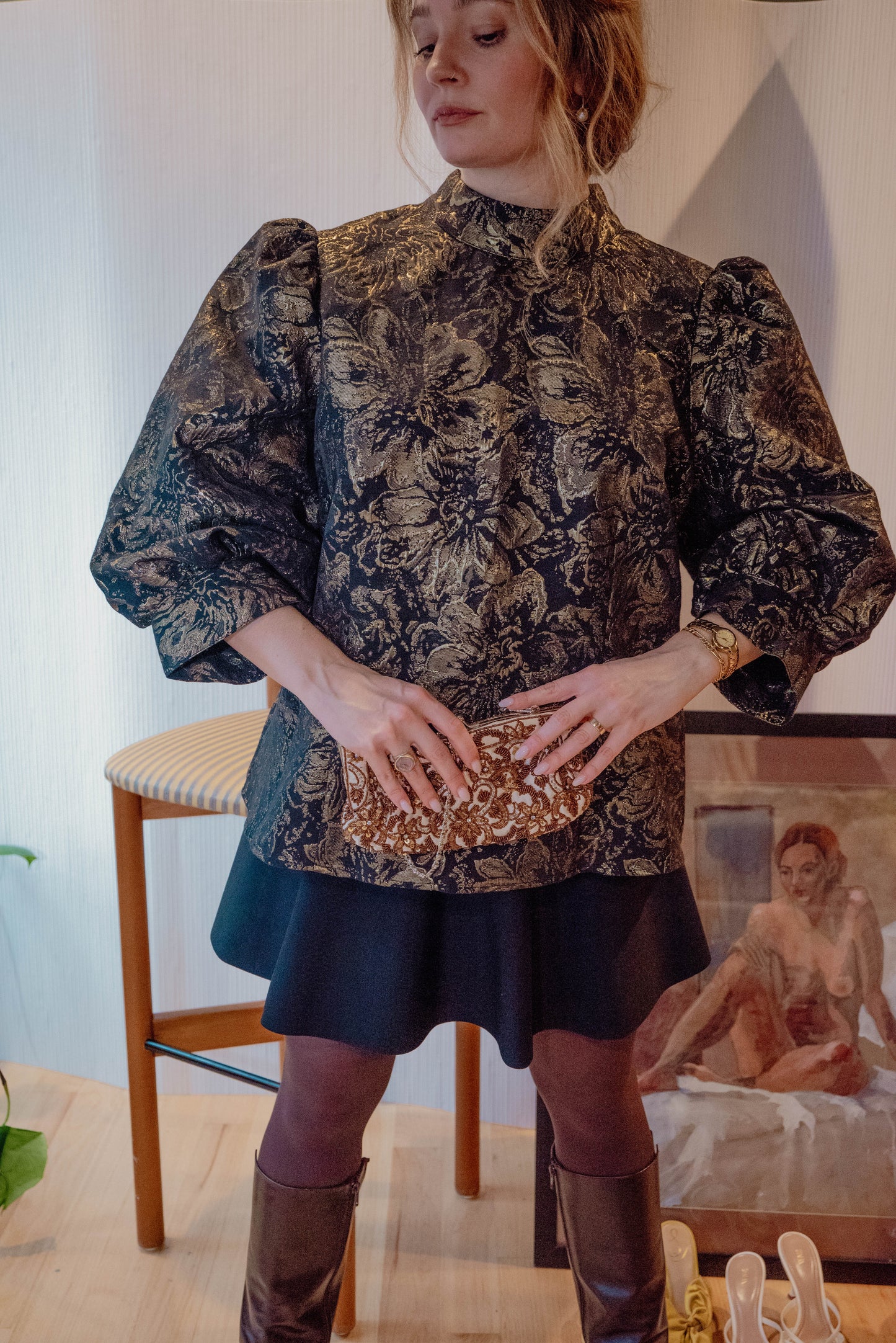 Chicago Vintage Boutique owner poses in a regal Jacquard blouse with large sleeves for her dinner party themed vintage clothing drop.