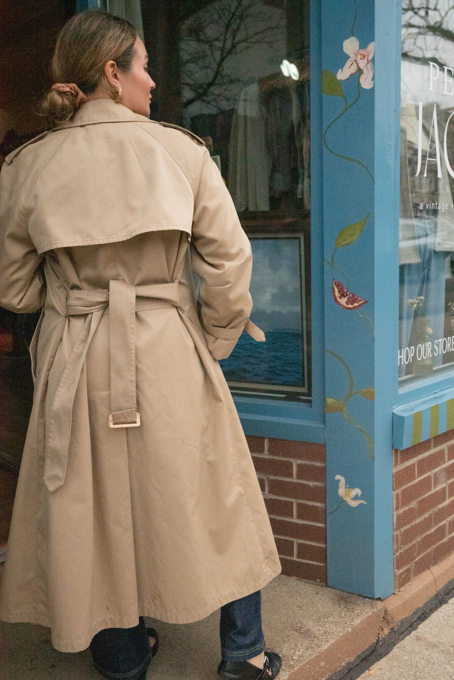 Woman poses in London Fog Trench Coat with plaid lining in front of Petals and Jackets boutique in Chicago, Illinois.