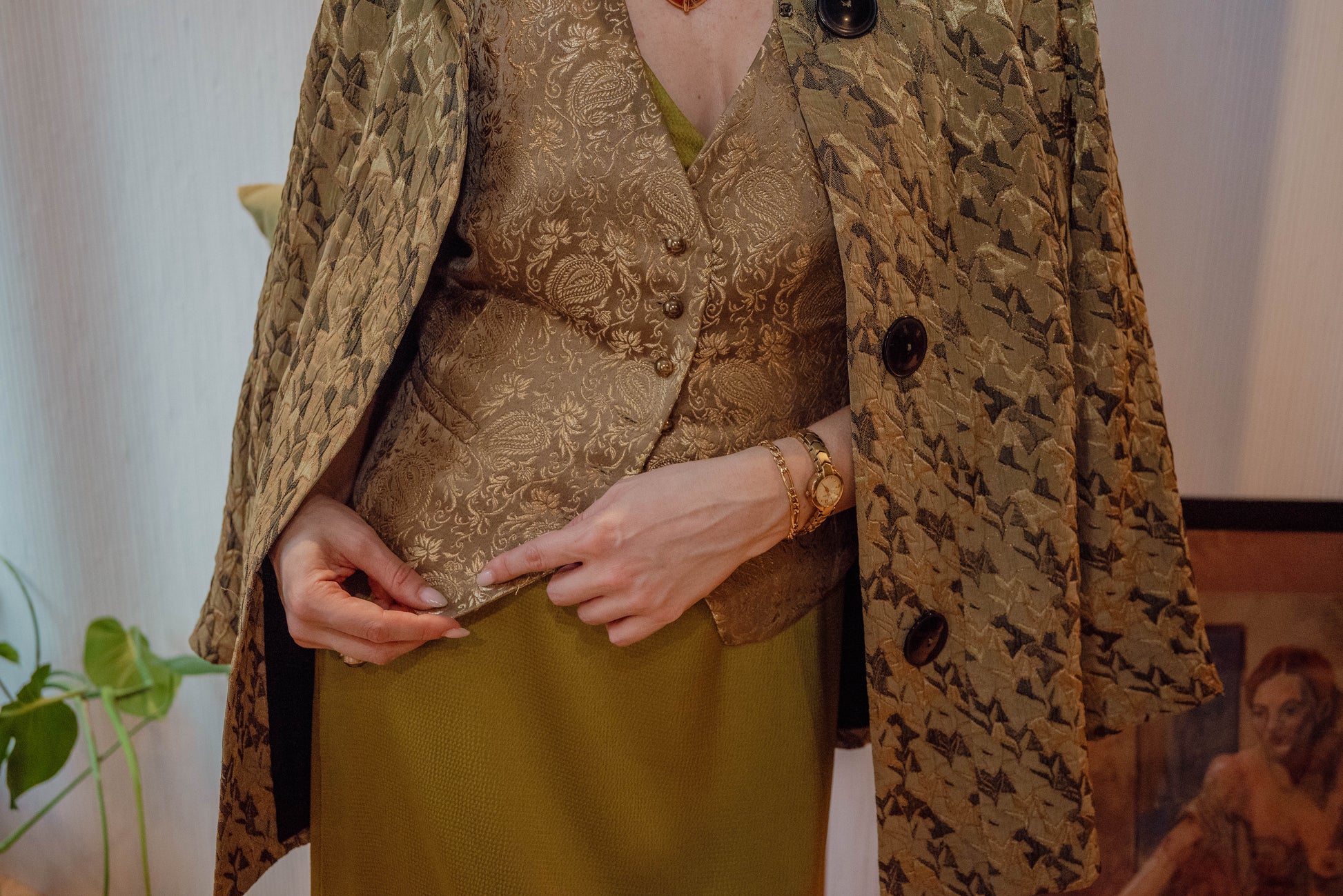 Woman wears a green patterned canopy jacket for a timeless holiday style from Chicago sustainable vintage boutique.