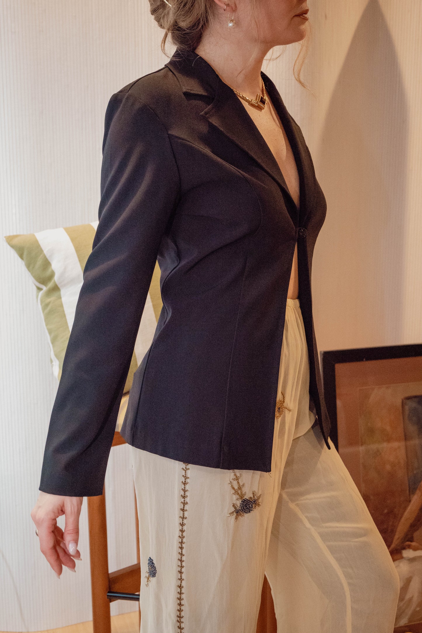 Chicago vintage boutique owner at Petals and jackets wears a chic black vintage blazer style top for a photoshoot for her new vintage style drops for the holiday season.