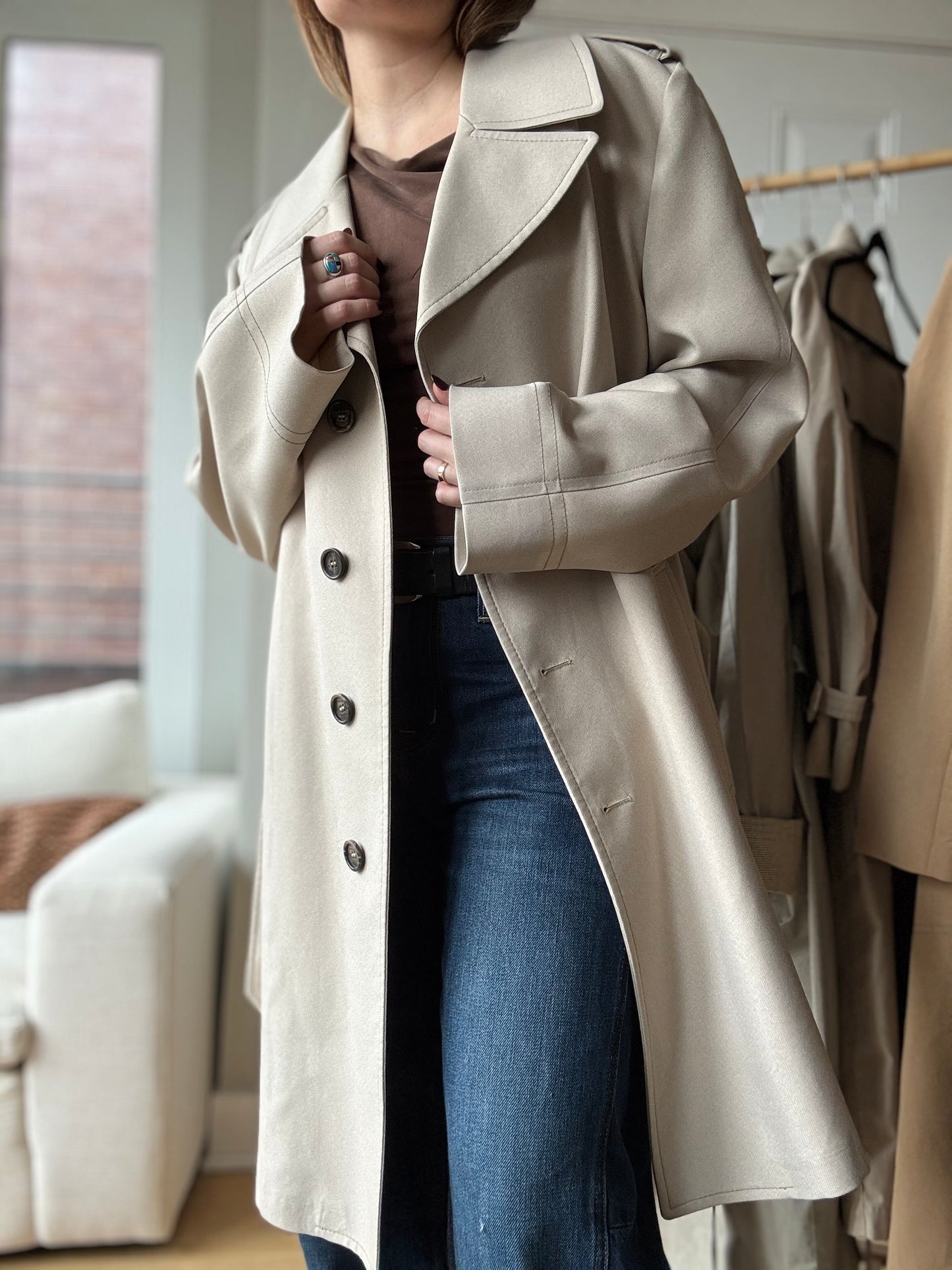 Woman wears a vintage trench coat from London Fog for a chic look over wide legged jeans in Chicago.