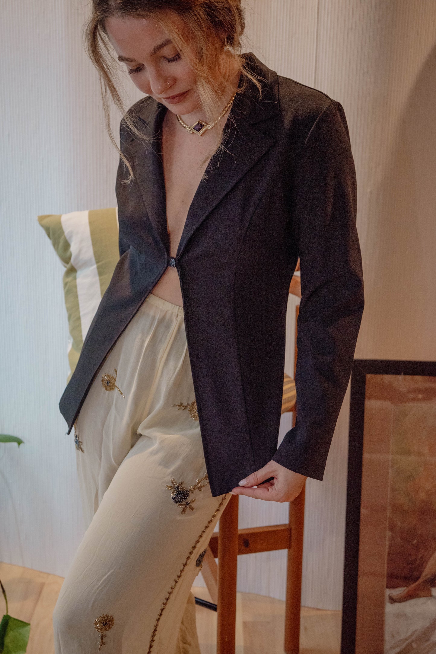 Chicago Vintage store owner wears a timeless vintage blazer top for a chic sustainable holiday outfit.
