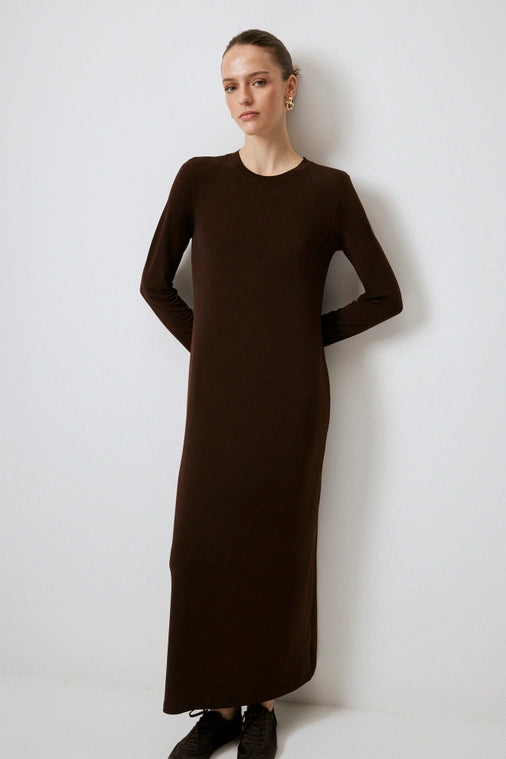 Woman poses in chic long chocolate brown dress from local Chicago woman's boutique Petals and Jackets.