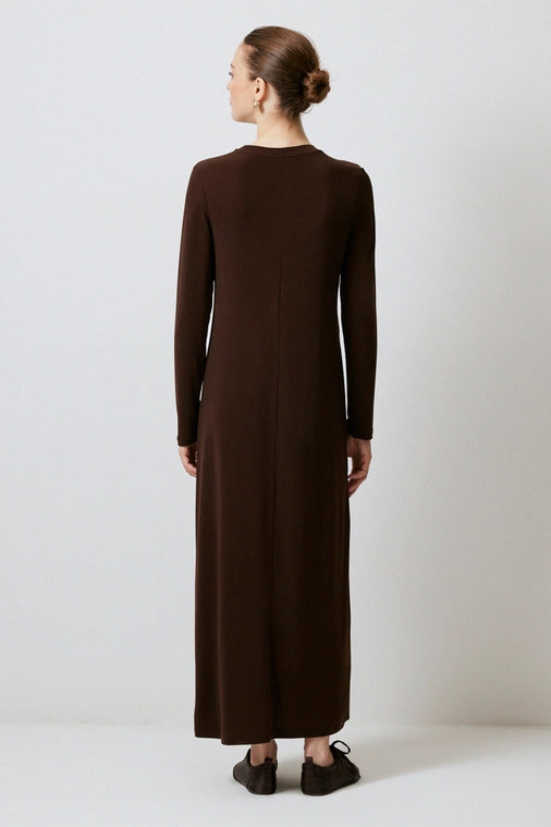 Woman wears long sleeve, brown dress from a local Chicago Boutique with staple picks.