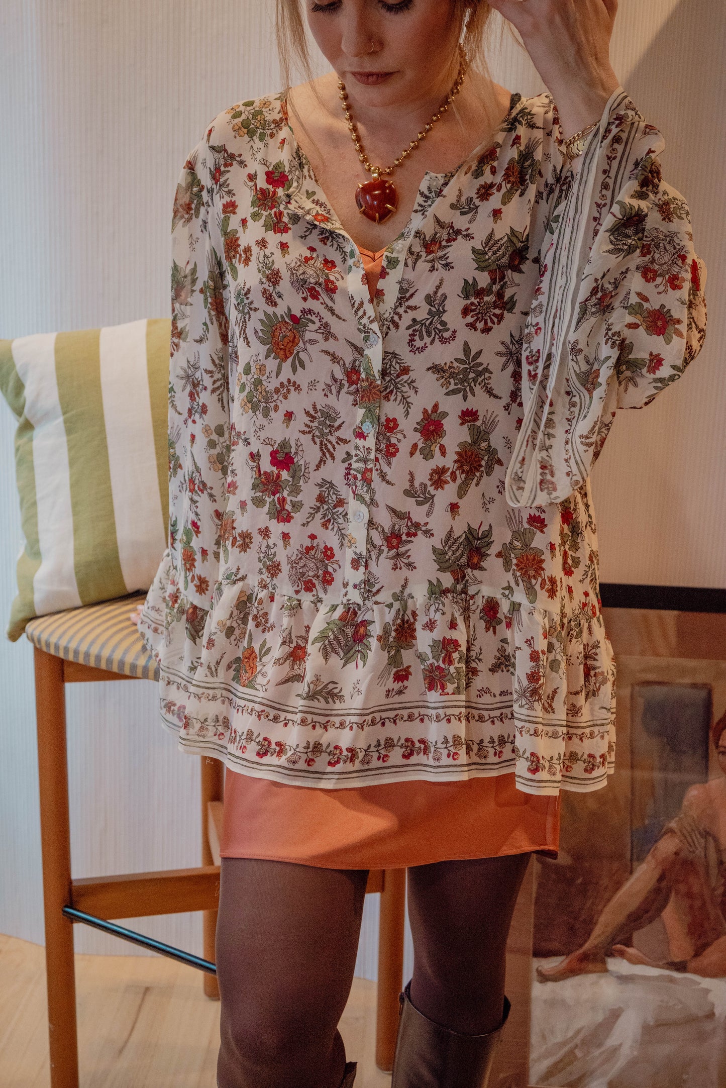 Chicago vintage boutique owner overlays a sheer boho style blouse on top of a mini peach dress for an autumn style look book for timeless style.