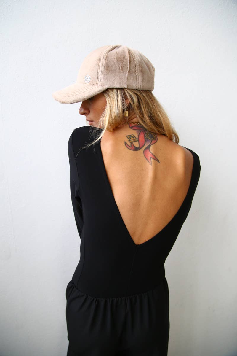 Woman wears deep v-cut black bodysuit from Chicago boutique in west town.