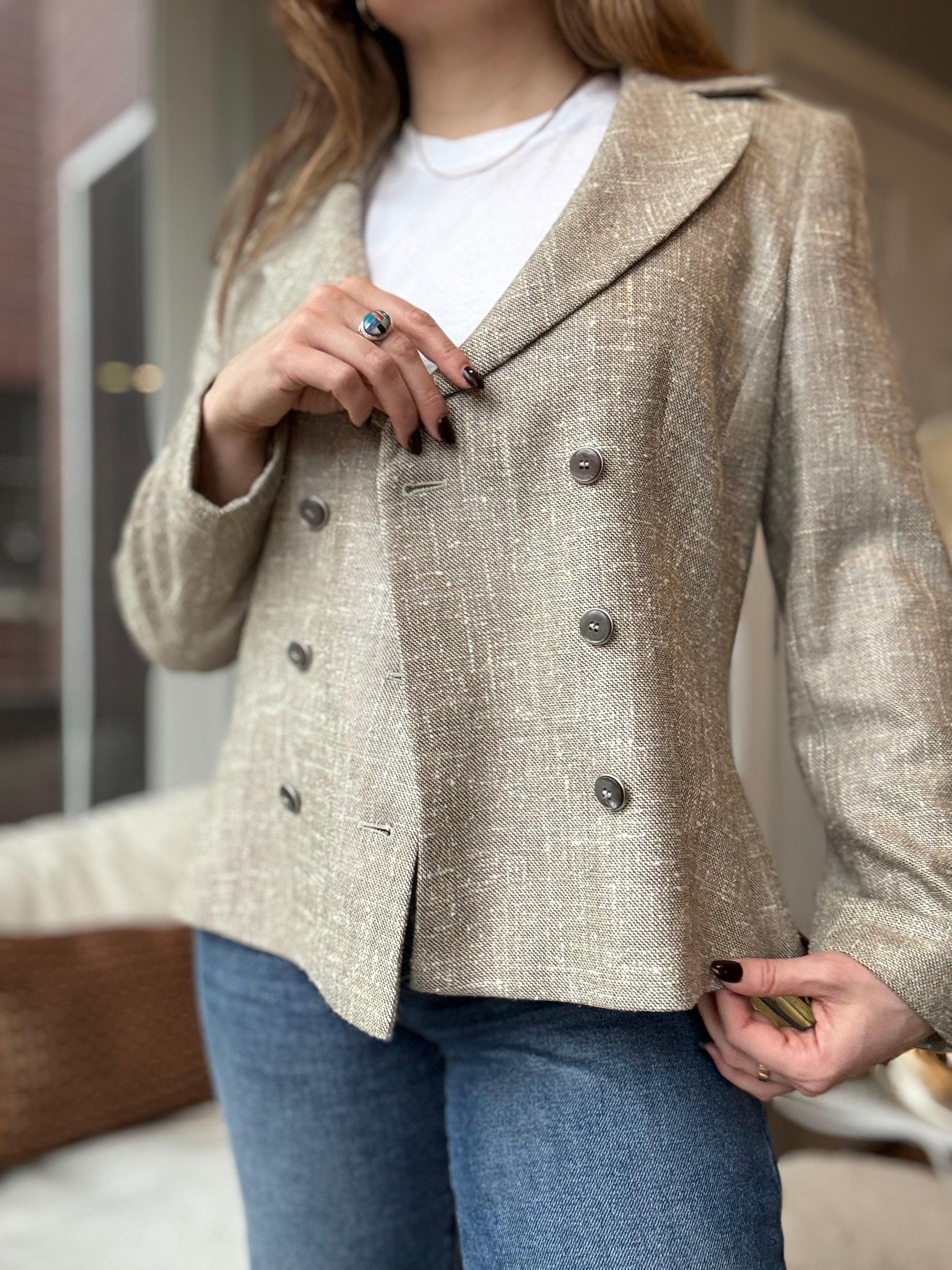 Woman wears a preloved Escada Twill double breasted blazer paired with wide legged jeans and turquoise jewelry for a unique tailored look. 