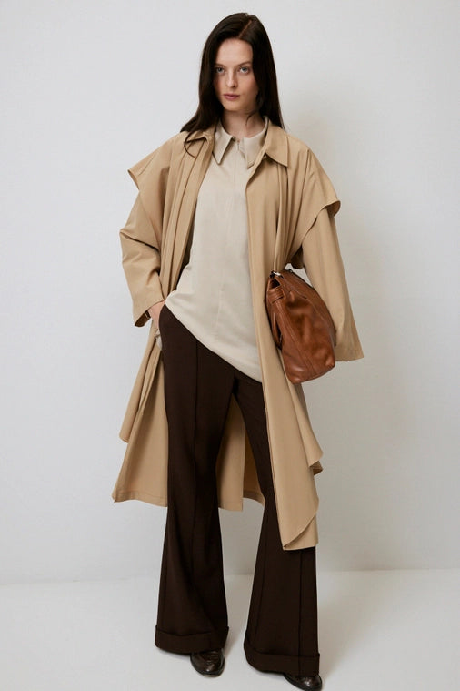 Woman models a uniquely layered chic french trench jacket located in local Chicago Vintage Boutique, Petals and jackets. 