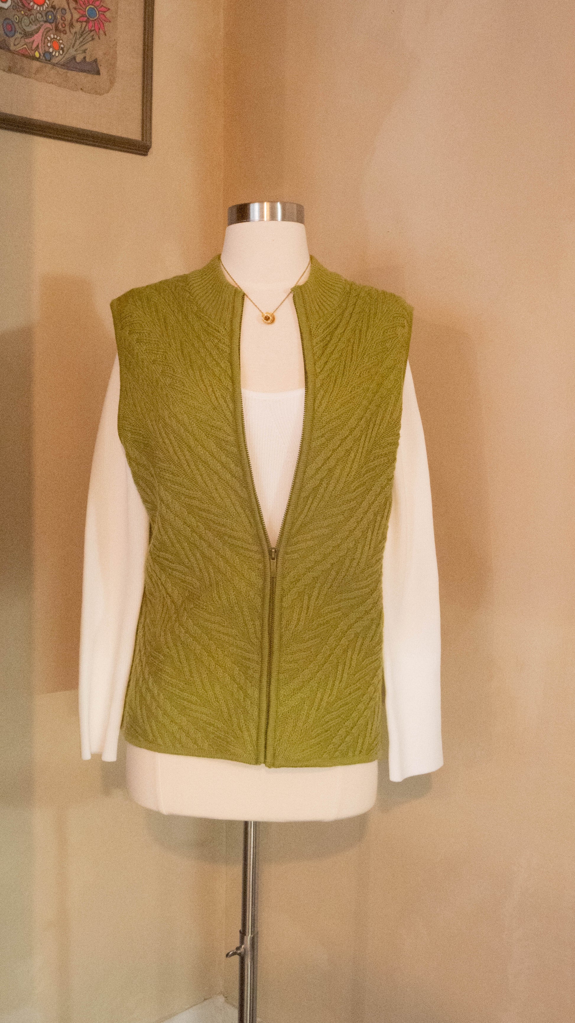 Green vintage vest sits on a mannequin against the wall in Petals & Jackets Chicago Vintage Boutique in West Town.