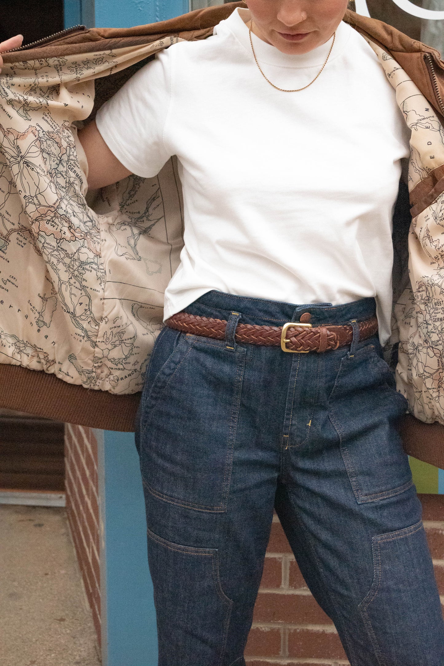 Woman flares her Vintage Jacket open to show lining of a Vintage map outside Vintage Boutique in West Town Chicago, Petals & Jackets. 