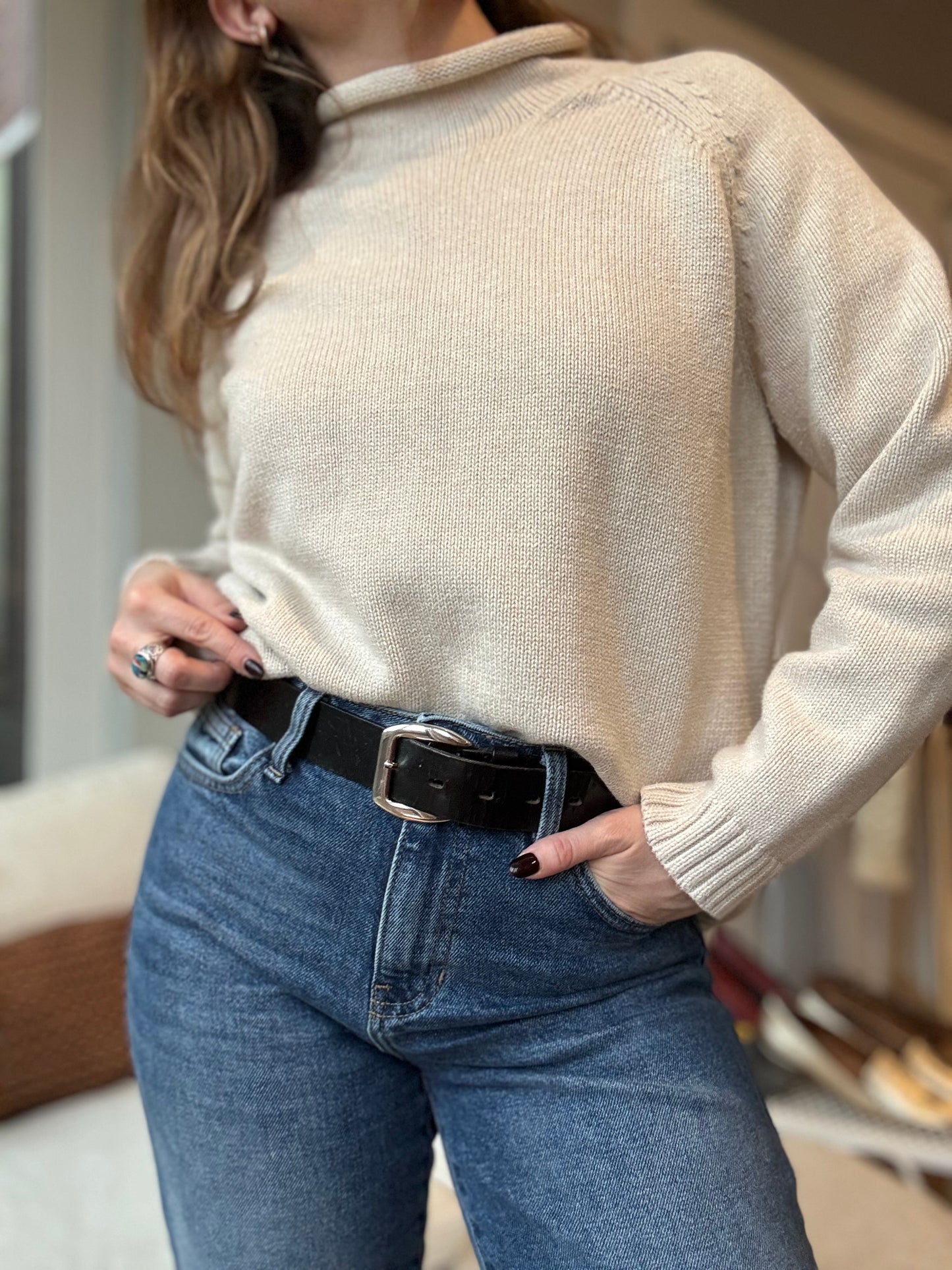 Woman wears a cozy cotton turtleneck paired with vintage jeans for an chic cozy winter style. 