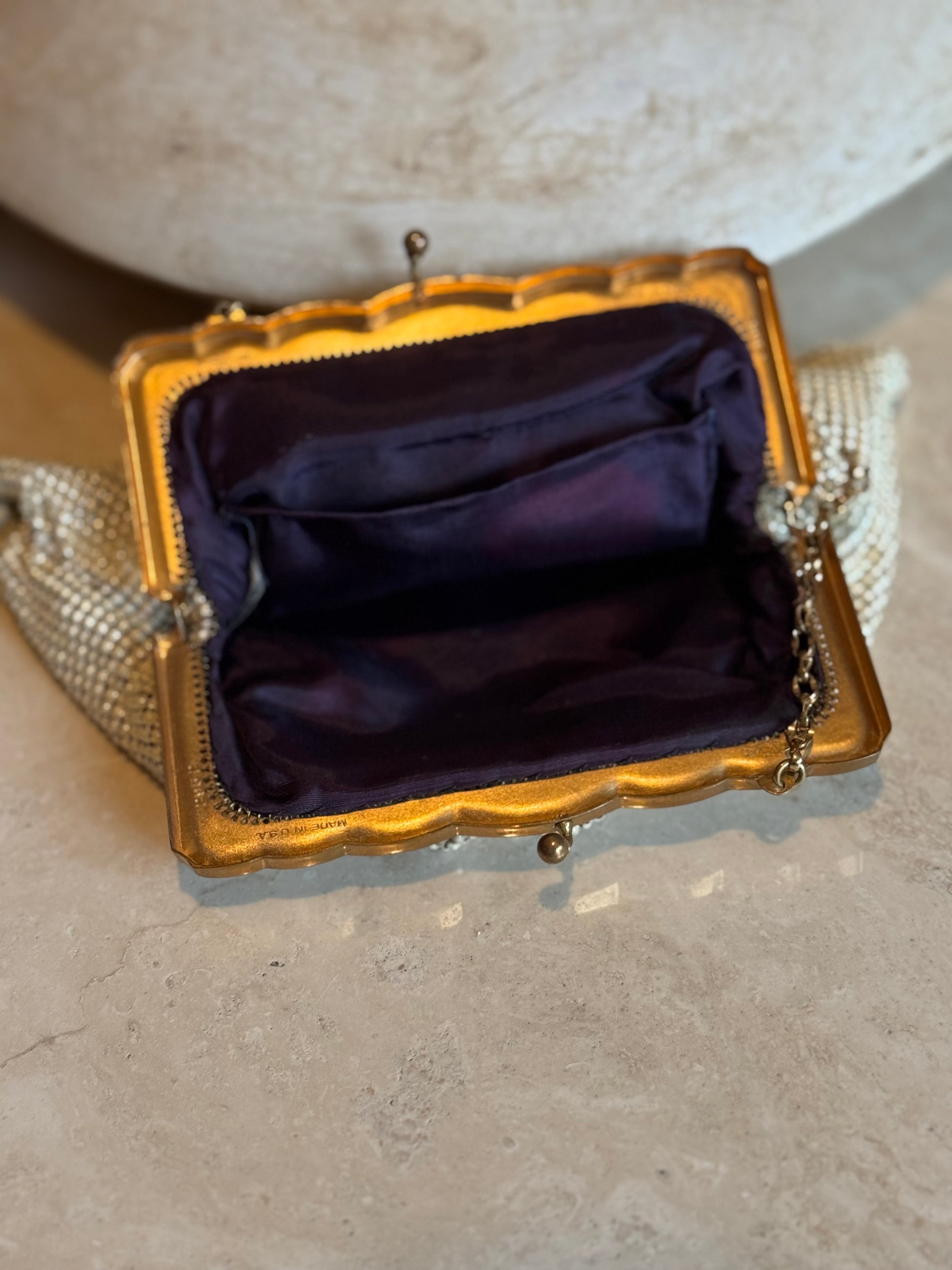 Chicago vintage store Petals and Jackets curates unique purses including a mesh Vintage Whiting and Davis change purse with gold detailing and royal purple lining. 