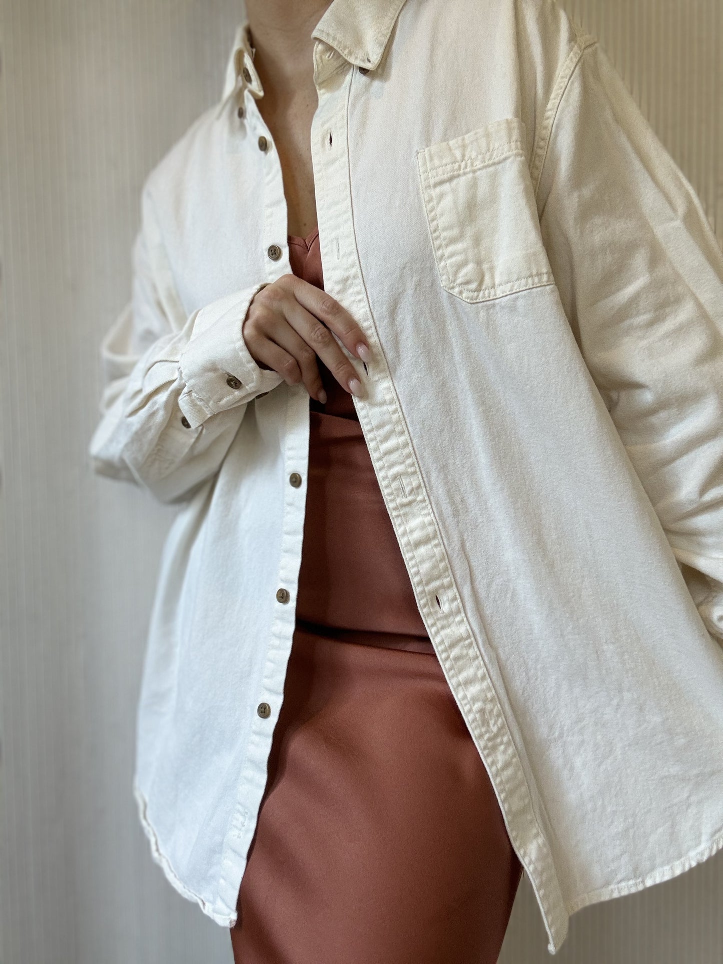 Woman wears a white cotton button-up shirt for a classic clean look for sustainable Christmas gifts from Chicago boutique. 